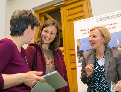 Eine junge Promovierende mit zwei Frauen im Gespräch.