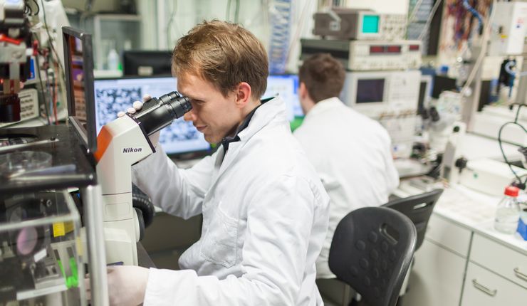 Student looking through the microscope in the lab