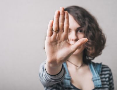 A woman stretches out her hand and signals stop.