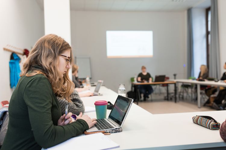 Eine Studentin sitzt im Seminarraum vor ihrem Laptop, Foto: Christian Hüller