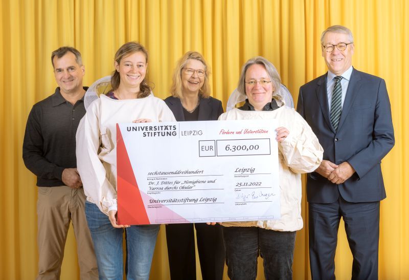 zur Vergrößerungsansicht des Bildes: Farbfoto: Prof. Dr. Birgit Dräger, Dr. Hubert Temmeyer und Prof. Dr. Harald Krautscheid von der Universitätsstiftung überreichen den symbolischen Scheck an die Fördermittelempfängerinnen Dr. Julia Dittes u. Dr. Ilka Emmerich