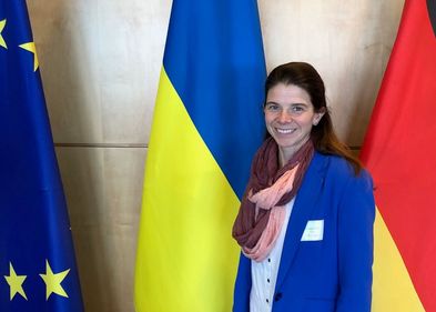 Die Politikwissenschaftlerin Prof. Dr. Solveig Richter vor den Flaggen der EU, der Ukraine und Deutschlands.