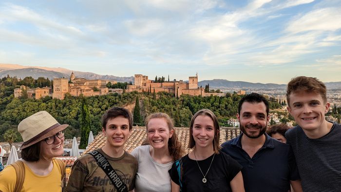 Zu sehen sind die Studierenden, im Hintergrund weiter entfernt zu sehen ist die Stadtburg von Granada