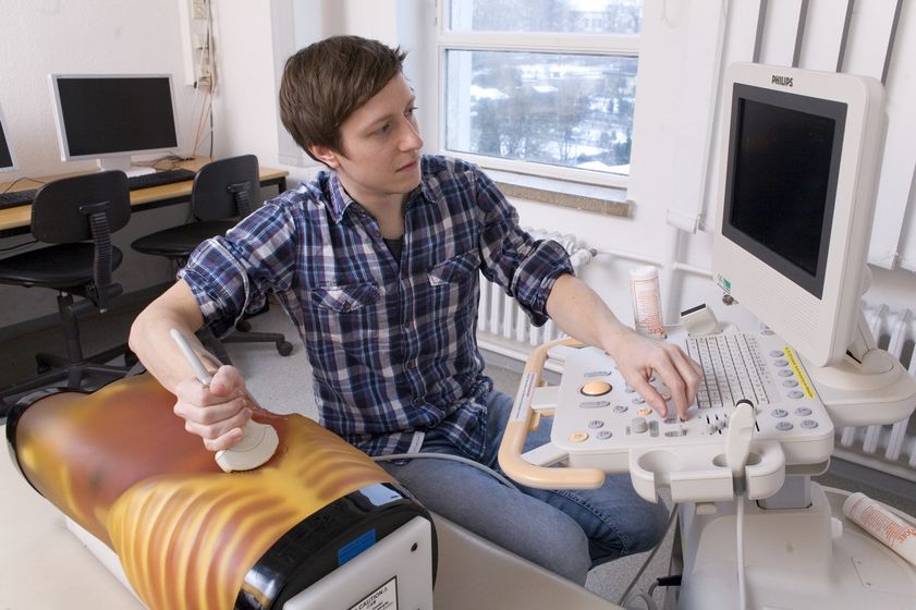 Student bedient ein Ultraschallgerät und untersucht einen Übungskorpus, Foto: Christian Hüller