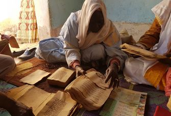 Zu sehen ist, wie in historischen Büchern mit vergilbten Papier geblättert wird.