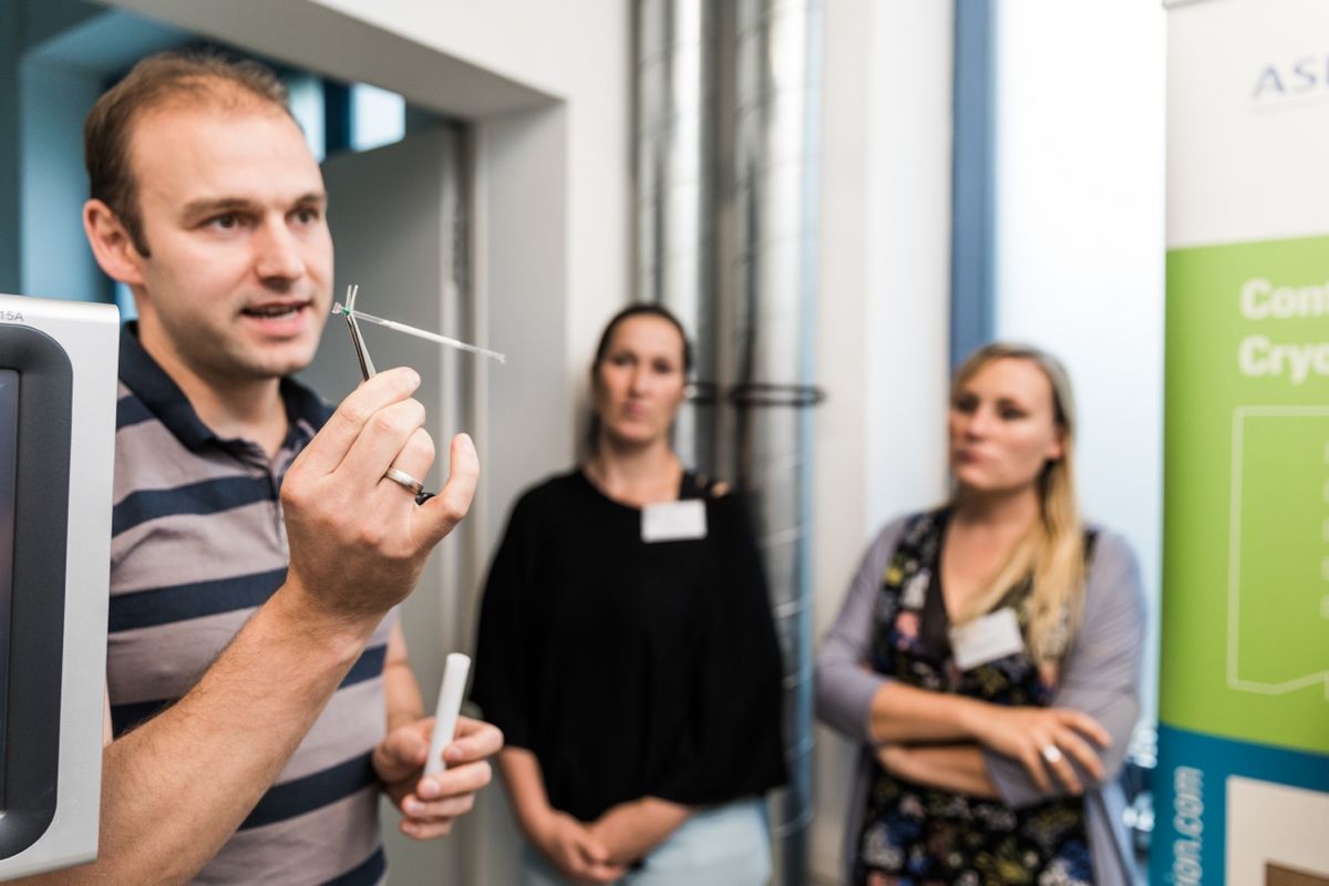 zur Vergrößerungsansicht des Bildes: Ein LIFE-Mitarbeiter hält eine Führung. Im Hintergrund sind zwei interessierte Zuhörerinnen zu sehen.