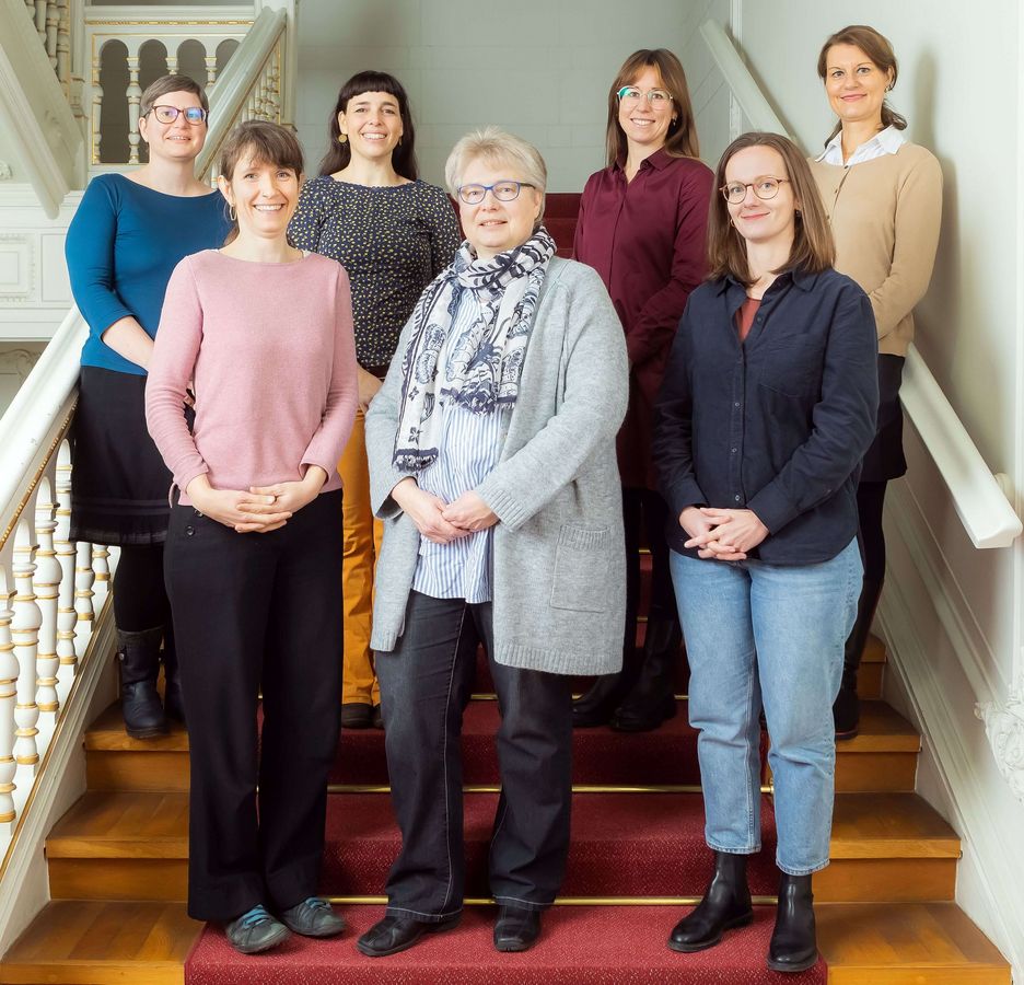 zur Vergrößerungsansicht des Bildes: Farbfoto: Das Team, bestehend aus sieben Personen, steht auf einer Treppe im Rektoratsgebäude.