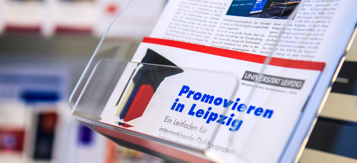 Information brochure about the doctoral studies at the Leipzig University displayed on a stand