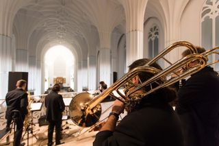 Ein Trompeter steht mit dem Rücken zur Kamera. Sein Instrument steht im Fokus des Bildes.