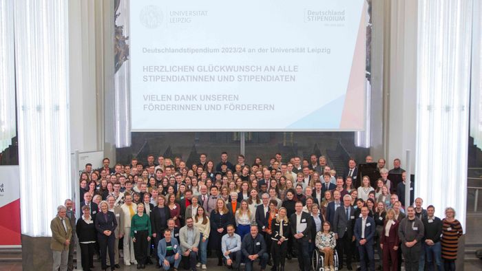 Förderer und Stipendiaten des Deutschlandstipendiums stehen für ein Gruppenfoto zusammen auf der Bühne im Paulinum