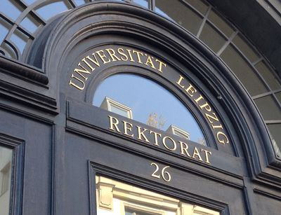 Farbfoto: Detailaufnahme der historischen Eingangstür zum Rektoratsgebäude in der Ritterstraße 26 aus dunklem Holz mit goldenem Schriftzug "Rektorat"