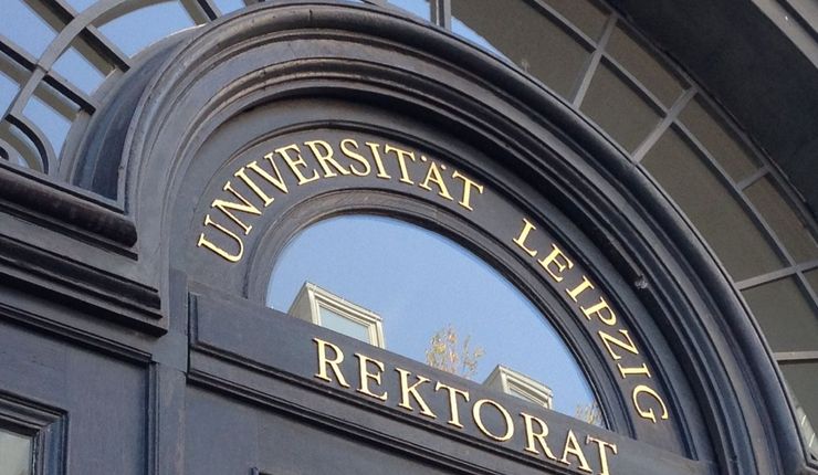 Foto: Zu sehen ist das historische Eingangstor zum Rektoratsgebäude in der Ritterstraße 26 aus dunklem Holz mit goldenem Schriftzug "Rektorat"
