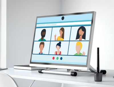 Auf einem Schreibtisch steht ein großer Computermonitor, der Symbole für einen Video-Chat anzeigt.