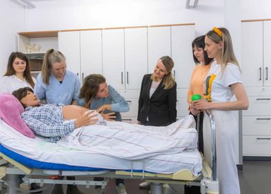 A participant practises using the artificial pregnancy belly. Photo: Swen Reichhold, Leipzig University Eine Teilnehmerin übt am künstlichen Babybauch.