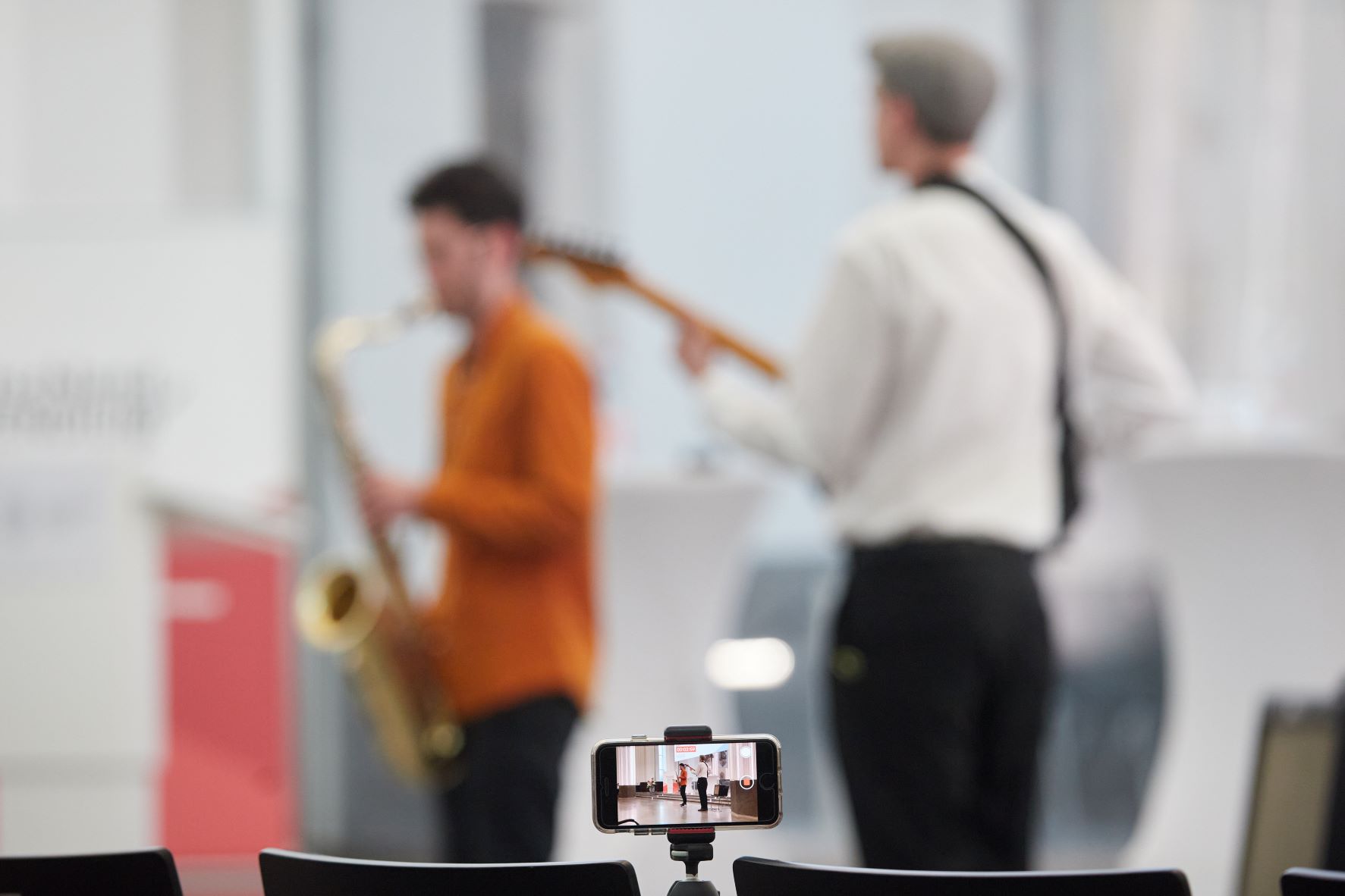 Farbfotografie: Jörn Kleinbrahm spiel Saxophon und Max Steinau spielt Gitarre auf der Bühne im Paulinum