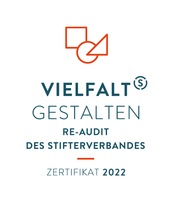 Grafik: Im oberen Teil der Grafik ist ein rotes Quadrat, ein roter Kreis und ein rotes Dreieck zu sehen, die sich jeweils etwas überlagern. Darunter steht in Großbuchstaben Vielfalt gestalten. In kleinerer Schrift steht darunter Re-Audit des Stifterverbandes. In der nächsten Zeile folgt eine kleine rote horizontale Linie. Darunter folgt der Schriftzug Zertifikat 2022