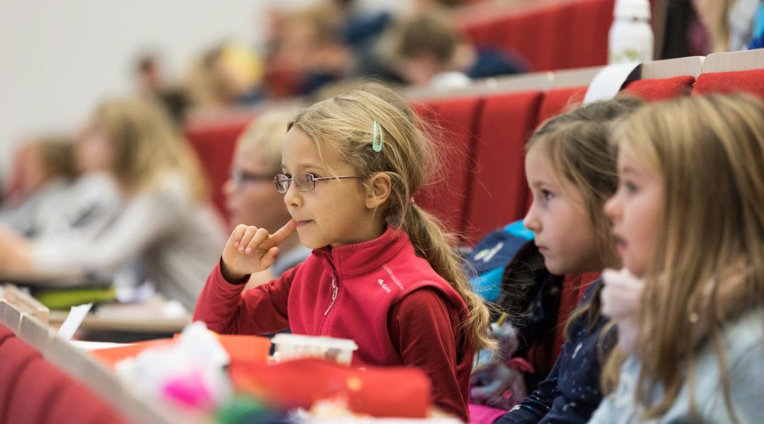 Kinder lauschen aufmerksam bei der Kinderuni-Vorlesung im Audimax